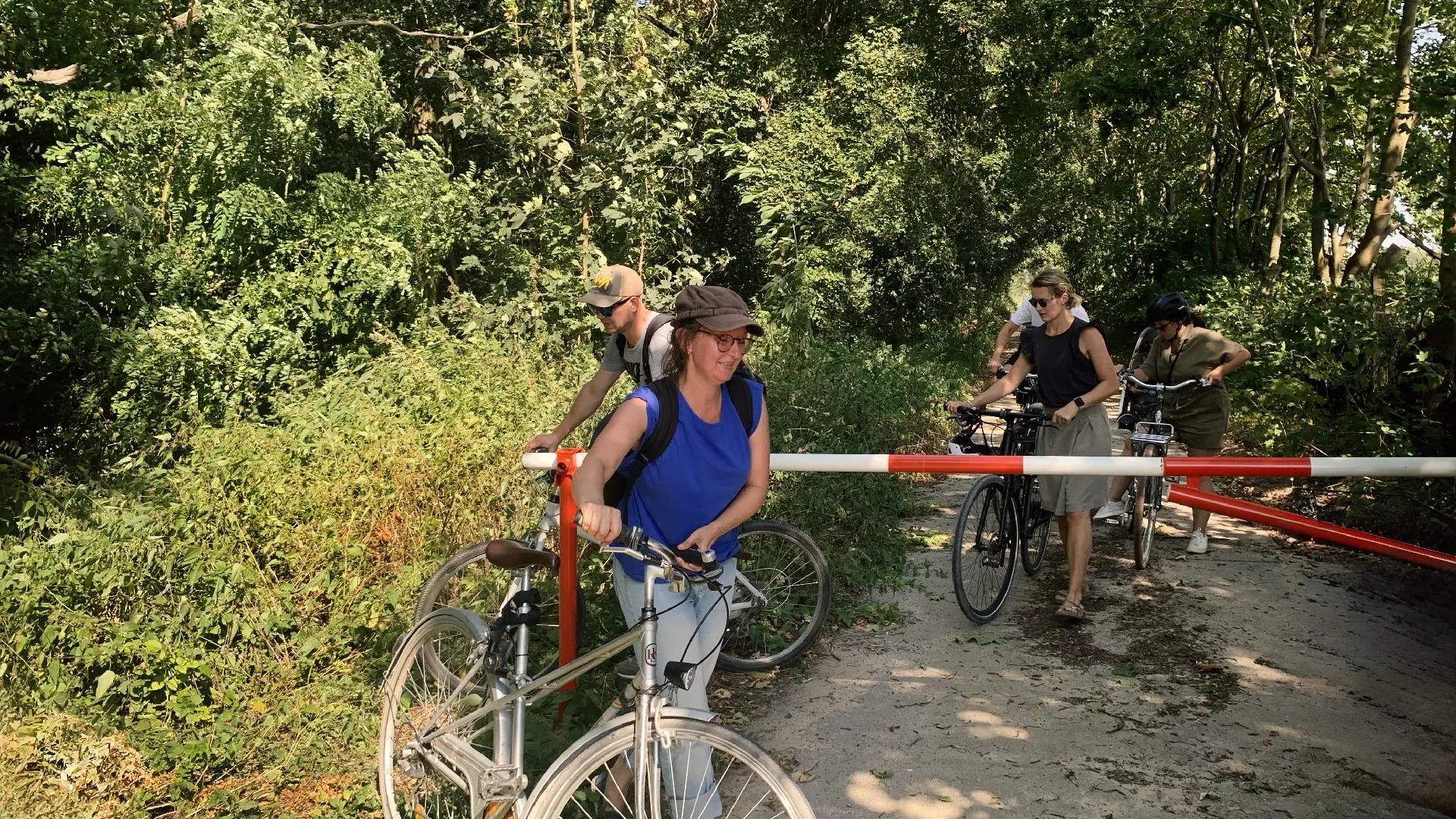 publicgarden Team, Personen schieben Fahrräder um Hindernis